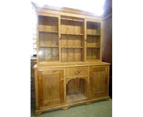 A vintage stripped pine kitchen dresser, the upper section partially enclosed by a pair of glazed panelled doors flanking two
