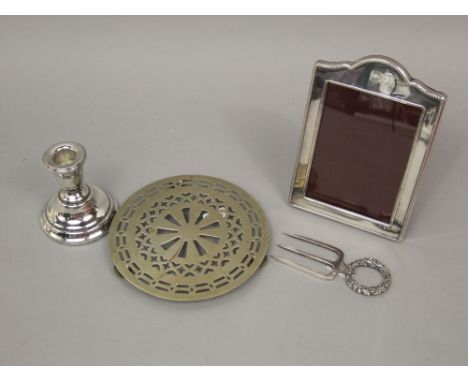 A mixed lot of silver and silver plate to include a silver easel picture frame, silver plated trivet, silver dwarf candlestic