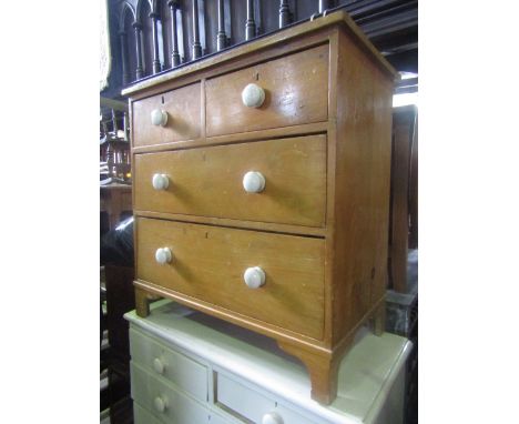 A Victorian stripped and waxed pine bedroom chest of two long and two short drawers with white glazed ceramic handles and rai