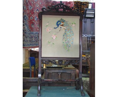 A 19th century mahogany firescreen of rectangular form with showwood frame carved C scroll and further carved acanthus detail