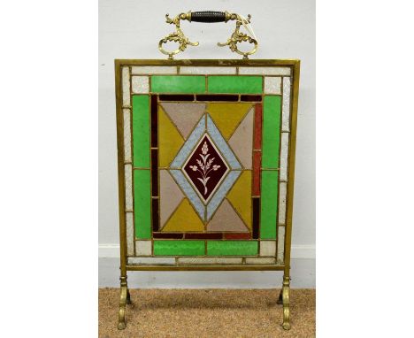An early 20th Century brass and stained glass firescreen, 46 x 80cms high. 