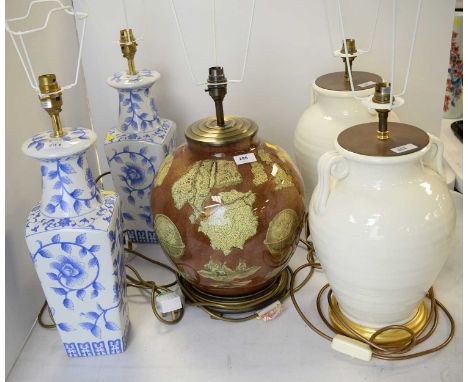 Pair of cream stoneware twin-handled urn table lamps, each on circular gilt base; together with a globular table lamp; and a 