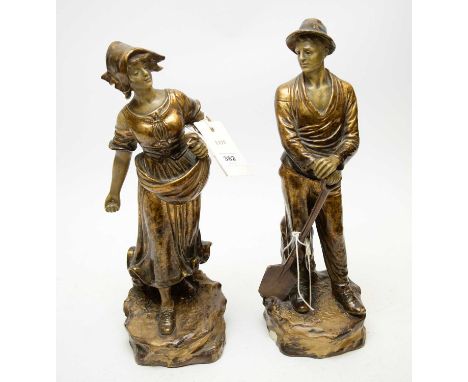 Pair of early 20th Century gilt decorated figures, possibly Goldscheider, modelled as a peasant man and woman, each signed 'J