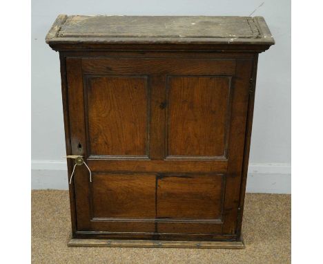 An oak cabinet, 18th Century and later, with ogee cornice above a single multi-panelled door enclosing single shelf to the in