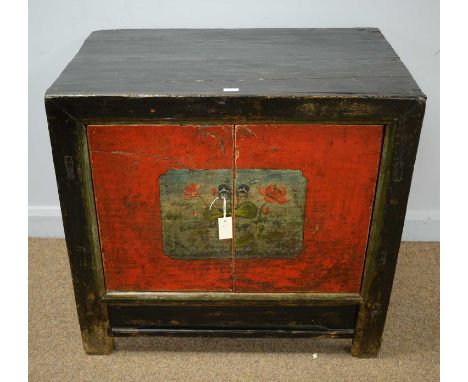 A Chinese lacquered side unit, in the antique style, the ebonised top above a pair of red doors decorated with floral designs