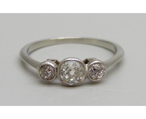 A white metal and three stone diamond ring, centre stone approximately 0.25 carat weight, 1.9g, M 