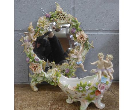 A continental porcelain mirror, flower encrusted and with cherubs playing musical instruments, and a bowl