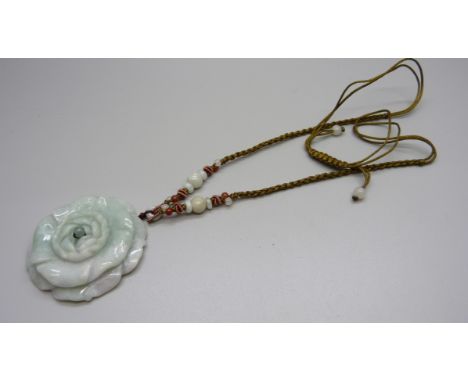 A carved jade pendant and silk thread necklace 
