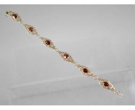 A 9ct Gold and Garnet Six Panel Bracelet, Each Panel with Oval Cut Stone Measuring 7.1mm by 5mm, Set in Four Claws on a Lozen