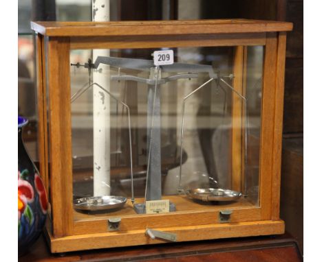 Set of laboratory balance scales in glass cabinet 