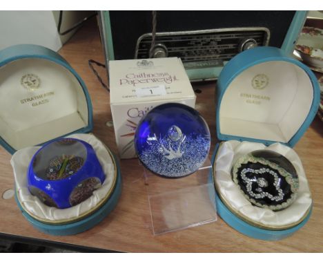 Three glass paperweights including two boxed Strathern glass and one Caithness
