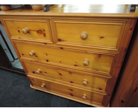 A modern pine chest of two short over three long drawers