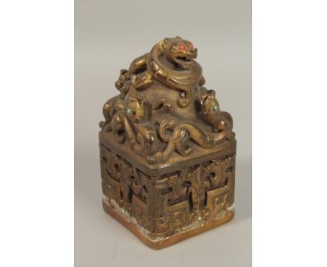 A CHINESE GILT BRONZE SQUARE DRAGON SEAL. 18cms high.