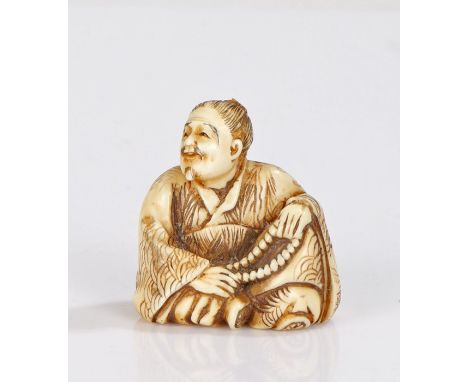 Japanese Edo period ivory netsuke, carved as a man with folded legs holding his Juzu beads, unsigned, 33mm high