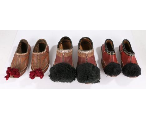 Three pairs of Greek Opanke Tsarouhi Pom-Pom shoes, the first pair with black pom-poms and deep red stitched shoe, the second