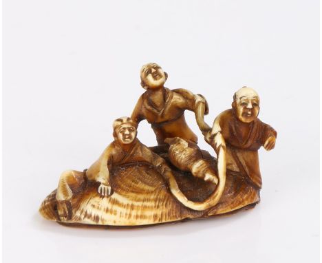 Japanese Meiji period Netsuke, carved with three figures clutching to a rope held to an oyster shell, a conch shell rested to
