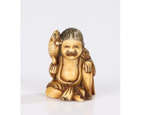 Japanese Edo period ivory netsuke, carved as a figure resting on his leg holding a toad up to his ear, his hair with leaf ter