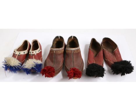 Three pairs of Greek Opanke Tsarouhi  Pom-Pom shoes, the first pair with red pom-poms and deep red and stitched shoe, the sec
