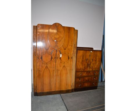 An Art Deco figured walnut part bedroom suite, comprising: a wardrobe; and a millinery cupboard.