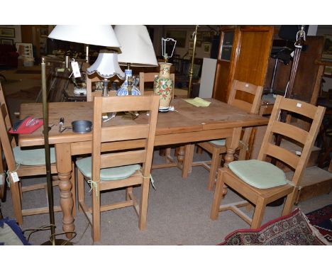 A modern pine rectangular extending kitchen dining table with spare leaf; together with six matching ladder back chairs with 