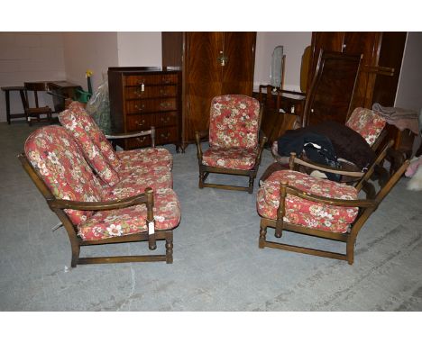 A four-piece dark stained Ercol sitting room suite, to include; three-seater settee, and three open armchairs.
