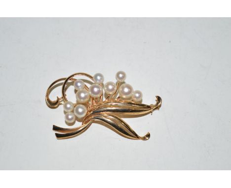 A Mikimoto pearl and yellow metal bar brooch, stamped 'K. Mikimoto K14', of scrolling design.