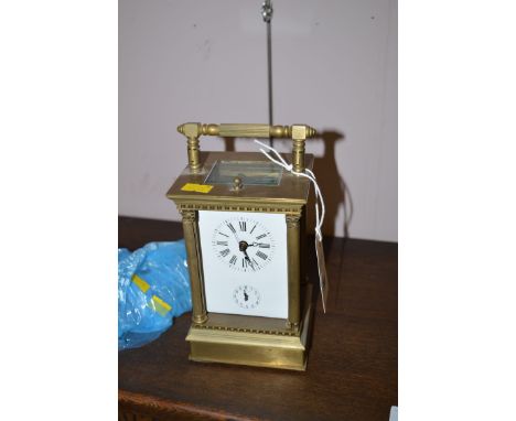 A large brass carriage clock, with repeating movement and subsidiary alarm dial, three glass panels removed but present.