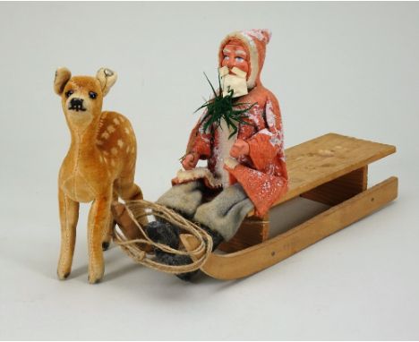 A composition headed Father Christmas on sledge, German circa 1900, with painted features, composition hands and boots, weari