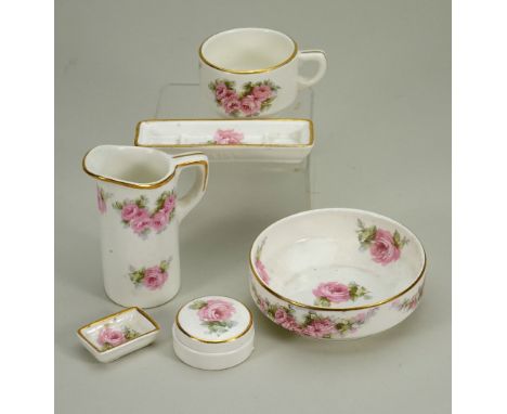 A Max Roesler china dolls Toilette set, German circa 1905, wash basin and jug, powder dish with lid, two dishes and chamber p