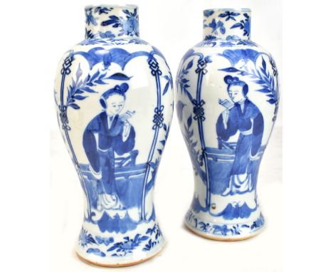 A pair of Chinese blue and white porcelain vases, painted with figures and exotic birds in landscape scenes, bearing Kangxi d