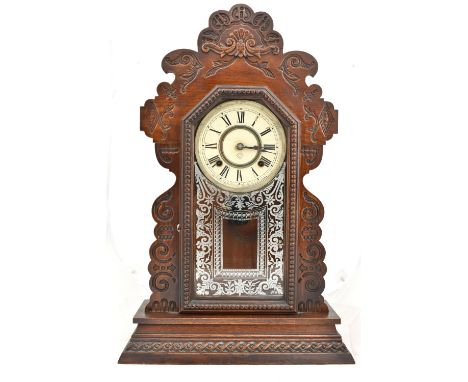 ANSONIA CLOCK COMPANY OF NEW YORK; a stained oak cased gingerbread mantel clock, the circular dial set with Roman numerals ab