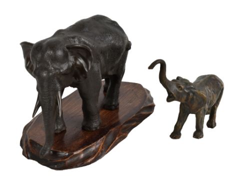 A Japanese Meiji period bronze figure of an elephant raised on an associated wooden stand, unsigned, length 28cm, and a furth