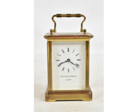 MATTHEW NORMAN; a brass cased carriage clock, the circular enamel dial set with Roman numerals, the movement backplate stampe