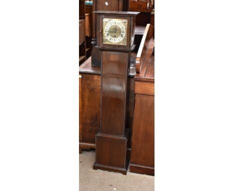 An early 20th century stained oak cased granddaughter clock, the silvered face with circular dial set with Roman and Arabic n