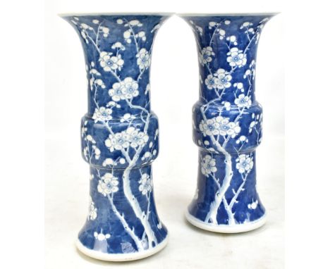 A pair of late 19th/early 20th century Chinese blue and white Gu vases, each painted with prunus flowers and bearing four cha