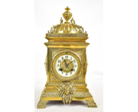 A late 19th century French brass cased mantel clock, the circular porcelain dial painted with Arabic numerals, cased with pro