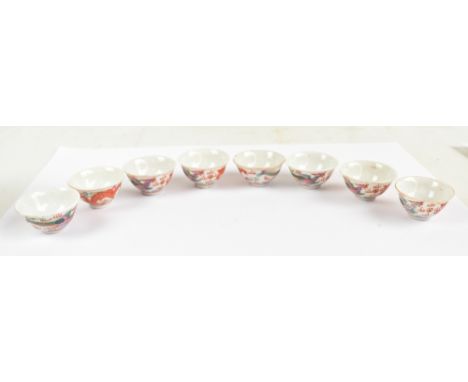 A set of eight 20th century Chinese porcelain miniature tea bowls decorated in enamels with dragon and phoenix chasing the Sa