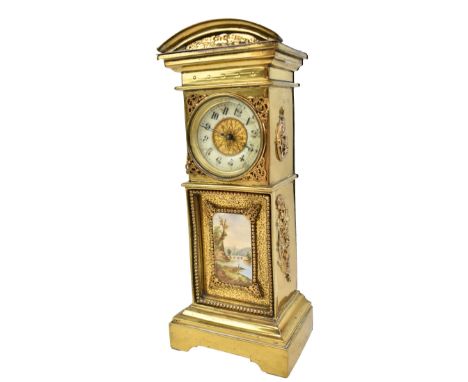A brass cased timepiece in the form of a longcase clock, the circular porcelain dial set with Arabic numerals (badly af), fea