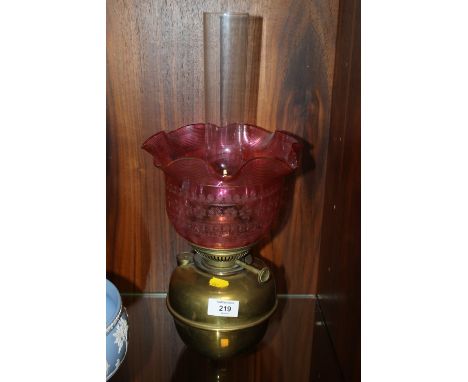 A VINTAGE OIL LAMP WITH PINK GLASS SHADE