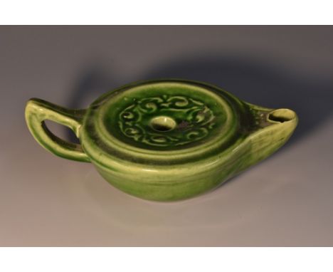 An art pottery novelty inkwell, as a Roman lamp, moulded with scrolls and glazed in tones of mottled green, 15cm wide, marked