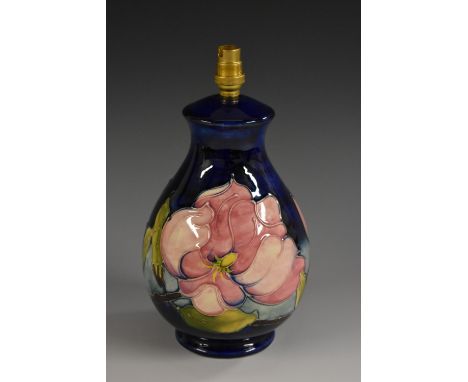 A Moorcroft Magnolia pattern baluster table lamp, applied with large pink flowers and slender leafy branches on a cobalt blue