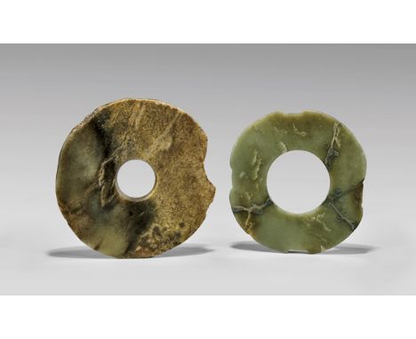 TWO ARCHAIC JADE RINGS: Bi & XuanjiTwo archaic, Chinese jade ritual rings: rough hewn bi, of green and brown coloration, and 