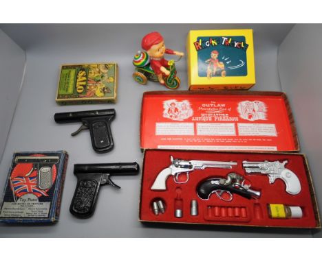 An Outlaw Miniature Firearms gun set, two vintage metal water pistols (tested, not working) and a Chinese tin plate ringing t