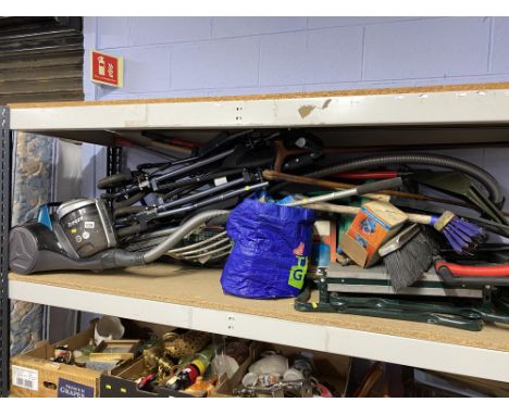 Shelf containing garden tools and a Breeze hoover