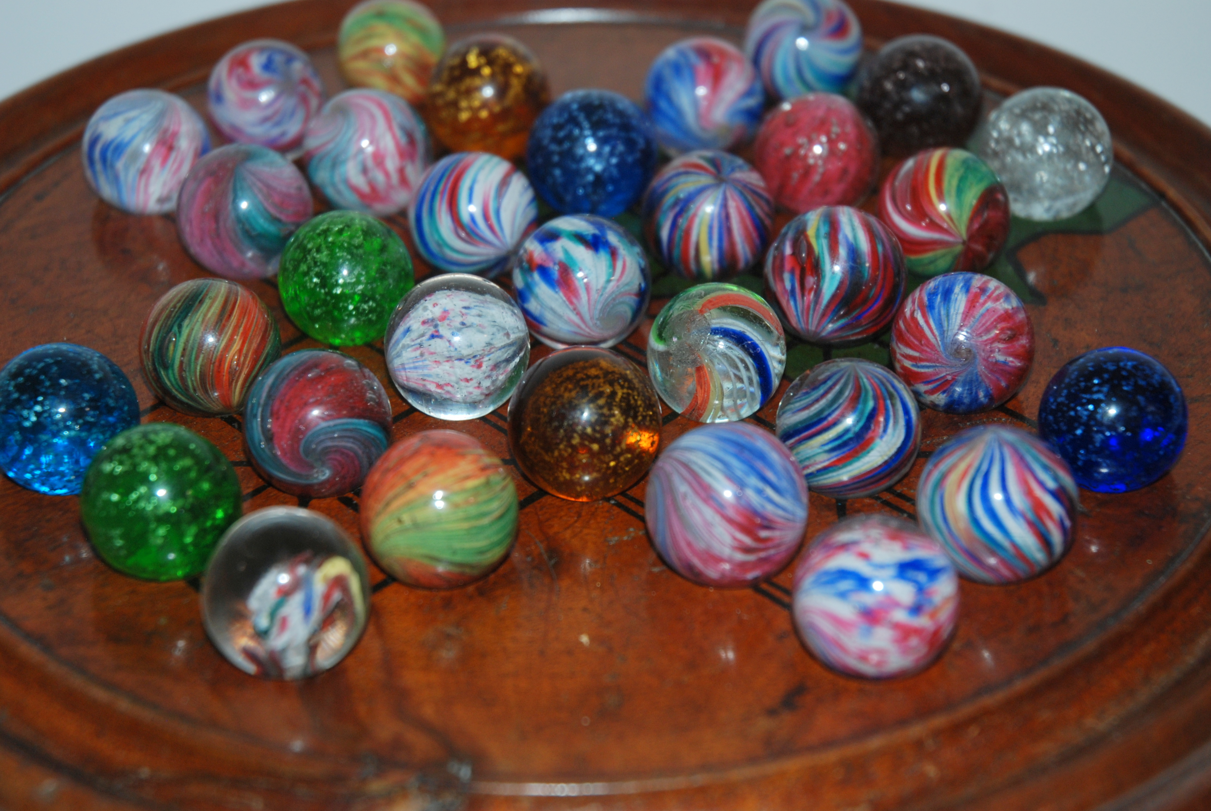 A COLLECTION OF VICTORIAN MARBLES approx 2cm diameter on turned wood