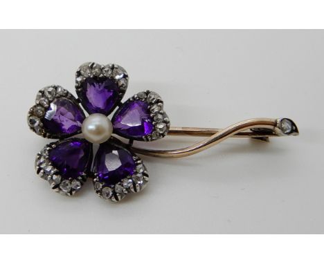 AN AMETHYST AND ROSE CUT DIAMOND FLOWER BROOCH mounted in yellow and white metal, dimensions 3.2cm x 1.7cm, weight 3.3gms Con
