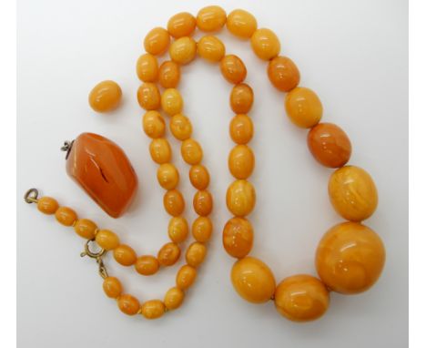 A STRING OF AMBER COLOURED BEADS AND A PENDANT largest bead approx 26mm x 23mm, smallest 7.1mm x 8.5mm, length of string 60cm