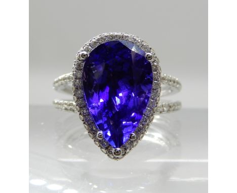 AN 18CT WHITE GOLD TANZANITE AND DIAMOND DRESS RING with insurance documents that state the pear shaped tanzanite is estimate