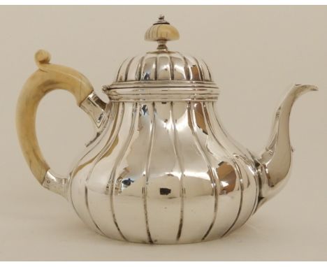 A VICTORIAN SILVER TEAPOT by Robert Garrard, London 1855, of bulbous baluster form with ribbed body, ivory finial and ivory h