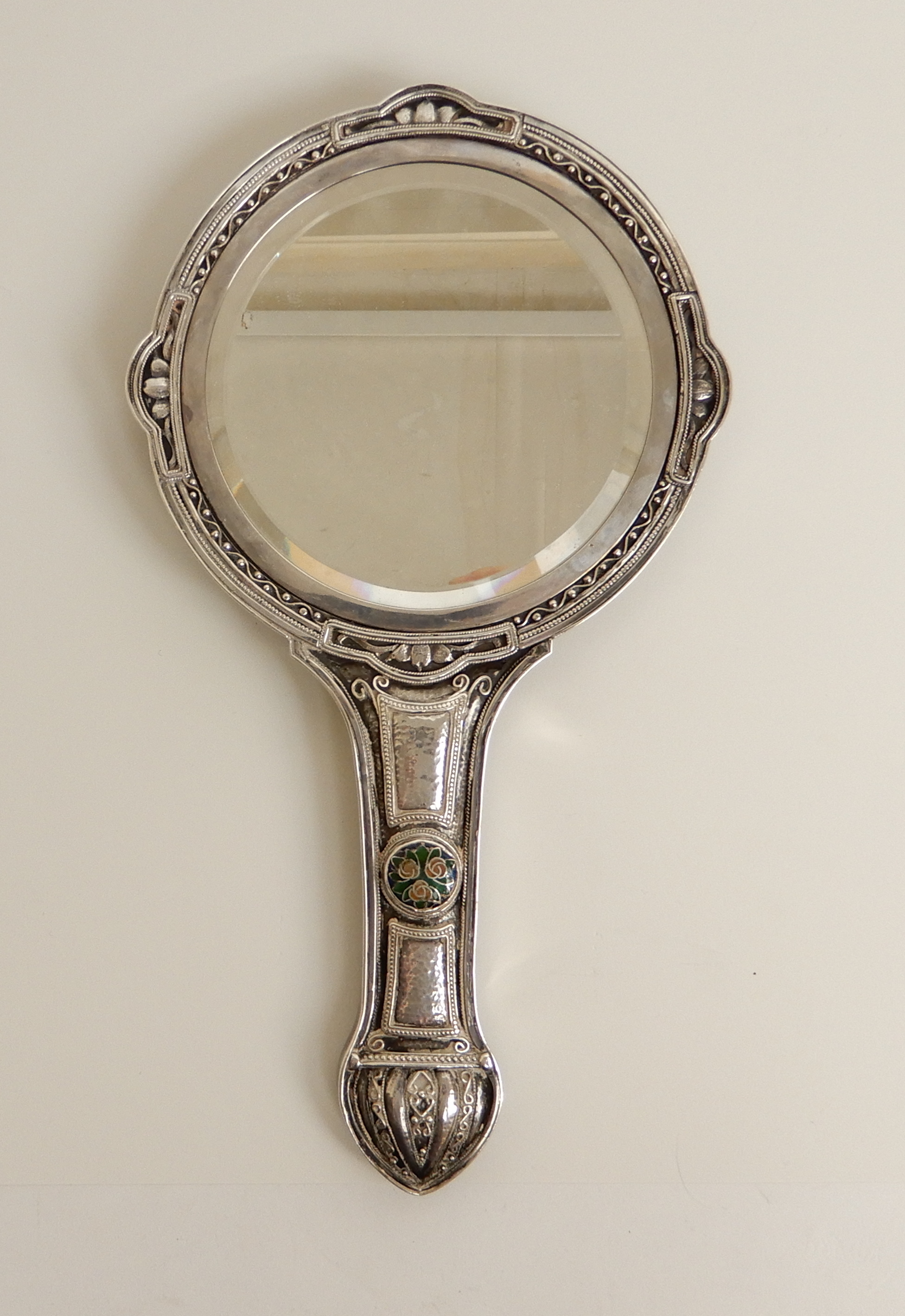 AN ARTS AND CRAFTS WHITE METAL HAND MIRROR the domed back with hammered ...